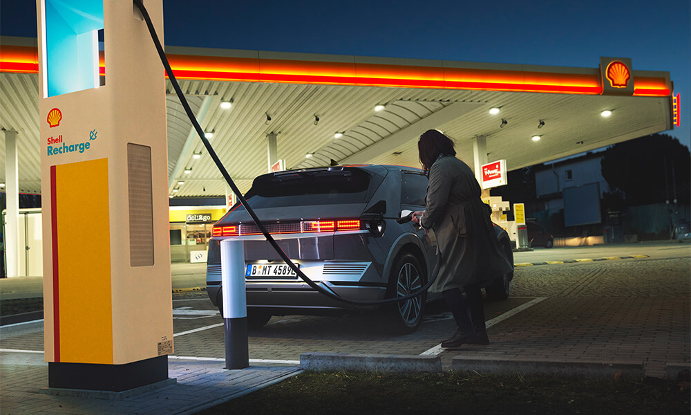 Person charging car with child looking up at the sky