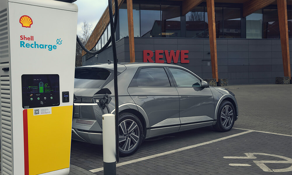 Person walking over to plug charging cable in to car
