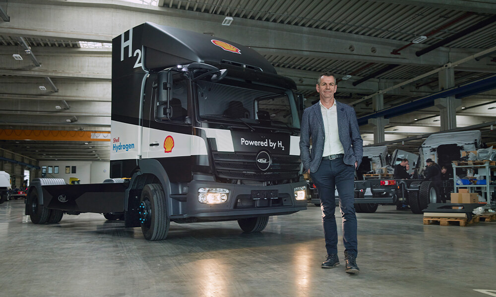 Person standing in front of hydrogen plant with hands on hips