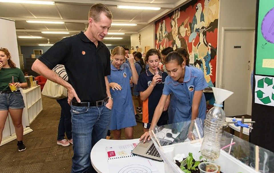 Teacher and students looking at laptop